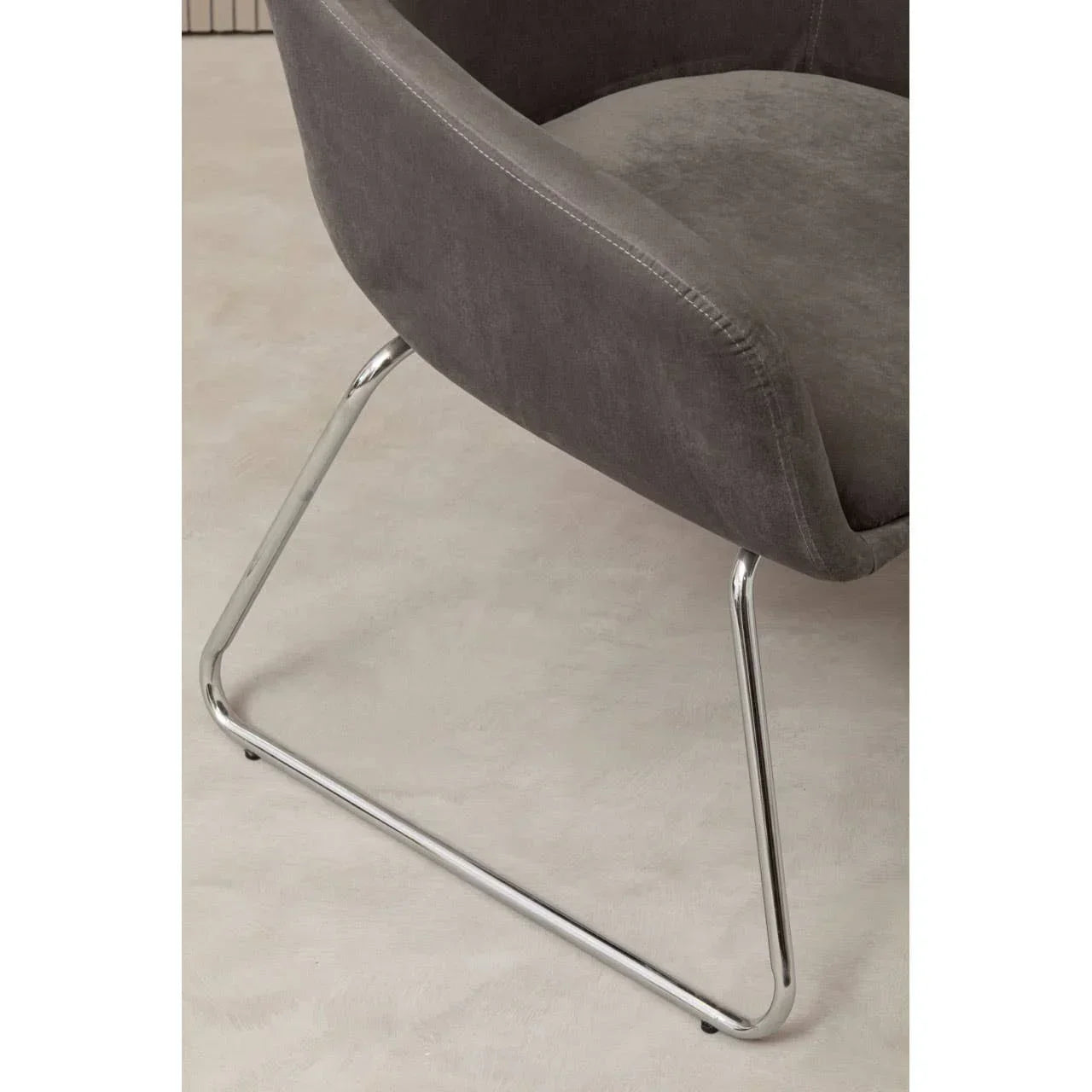 Grey fabric dining chair with chrome cantilever base on light floor