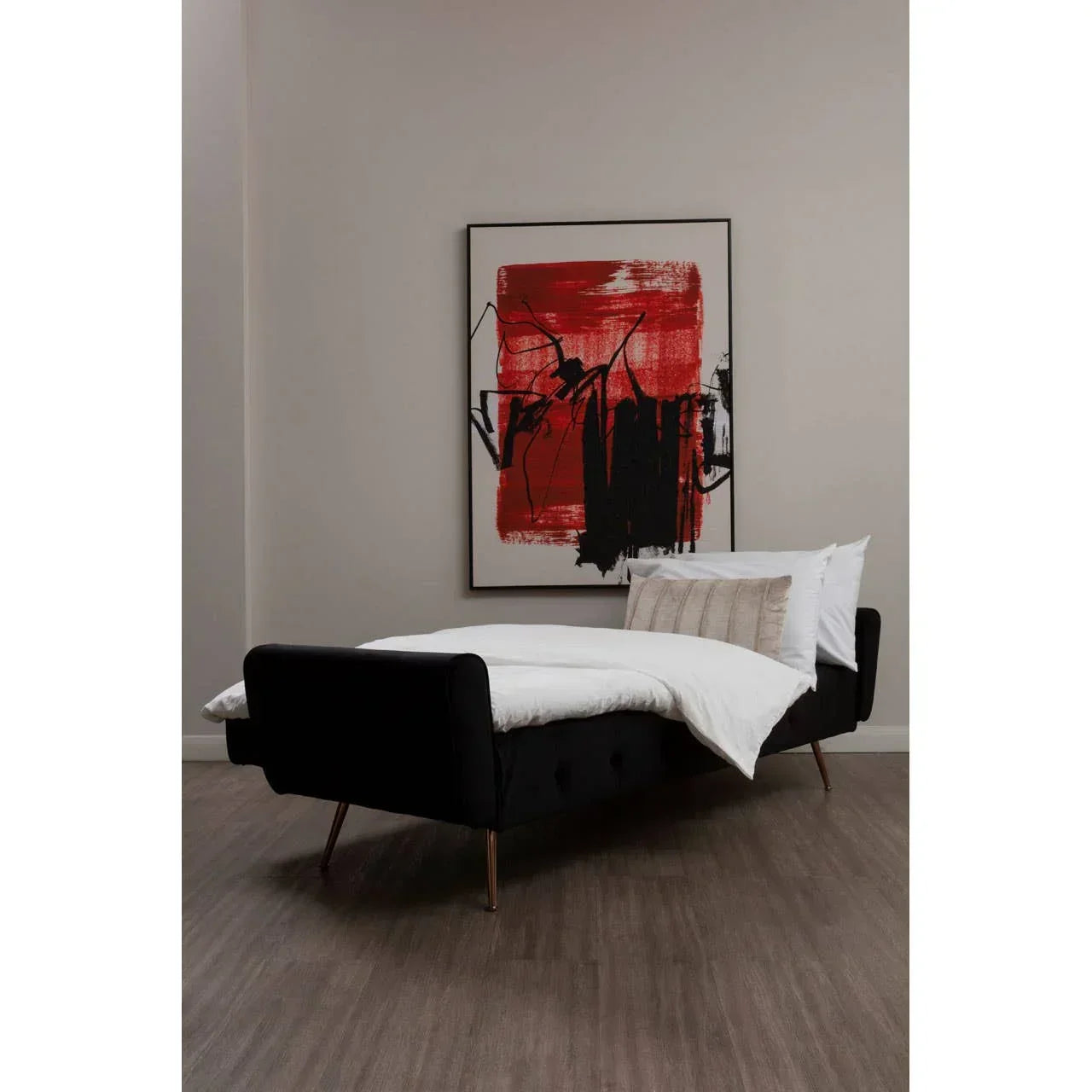 Black velvet sofa bed with bedding in modern room, abstract red and black wall art above