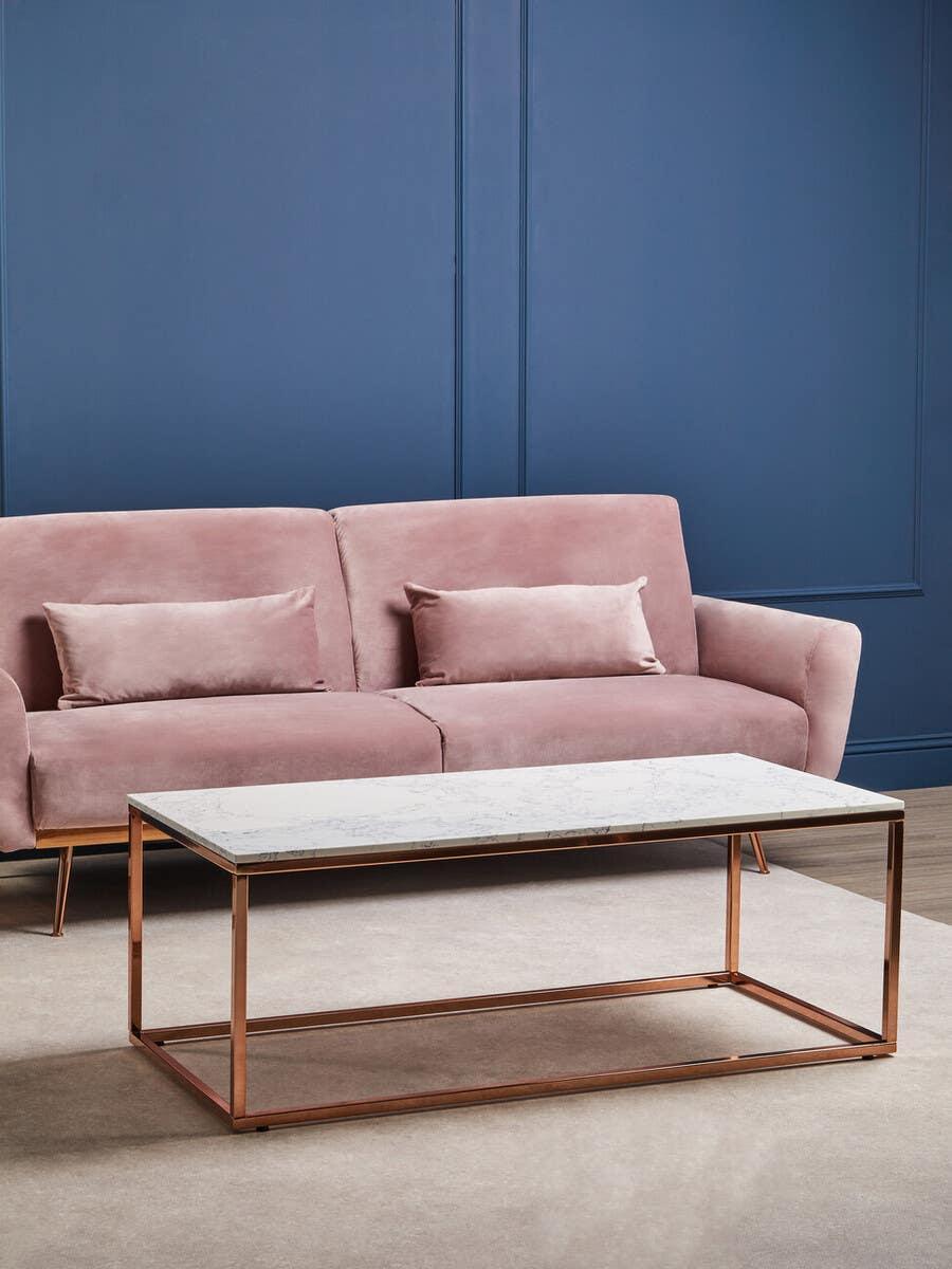 Pink velvet sofa with cushions and marble top coffee table with gold metal frame
