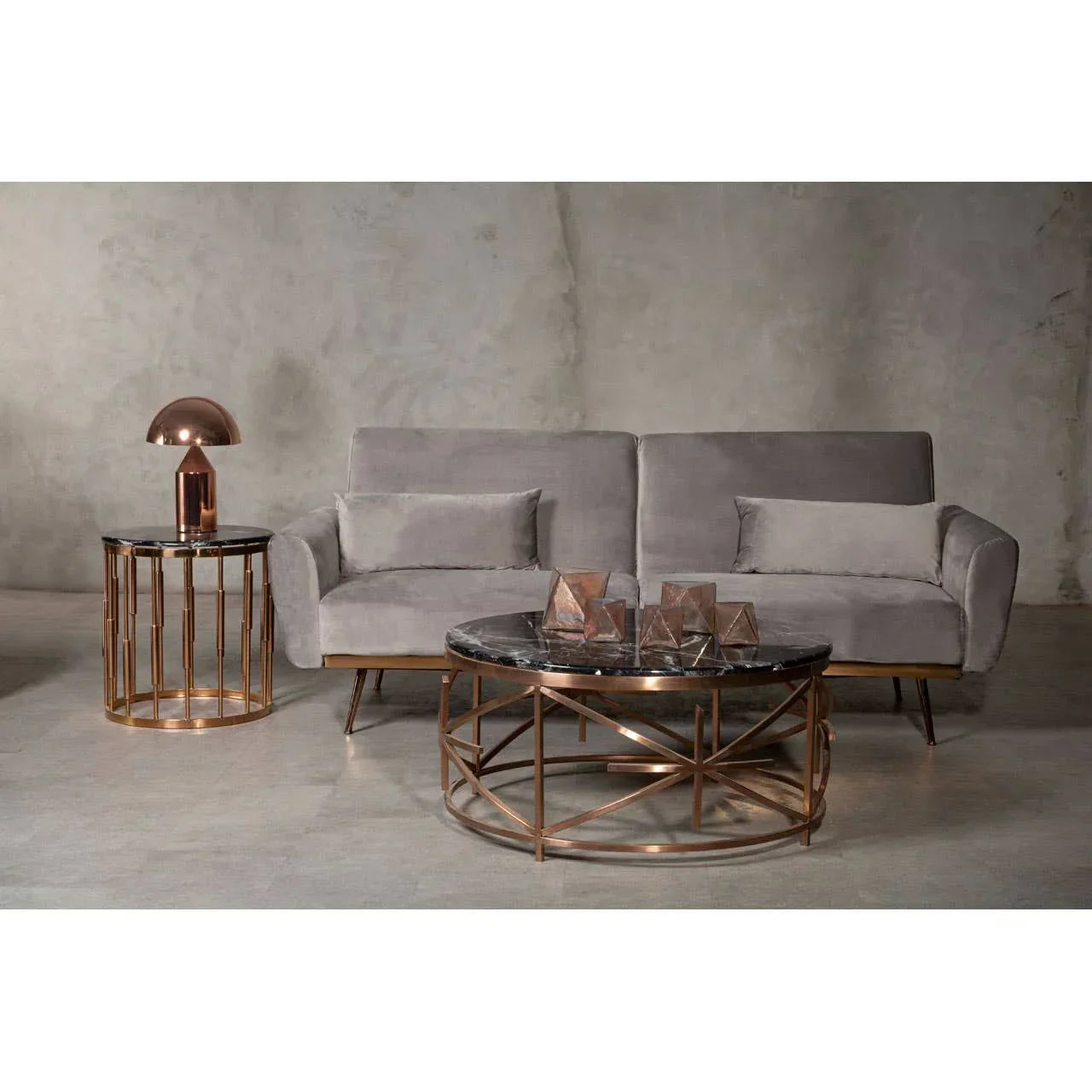 Grey velvet sofa with bronze frame, round marble coffee table and matching lamp table