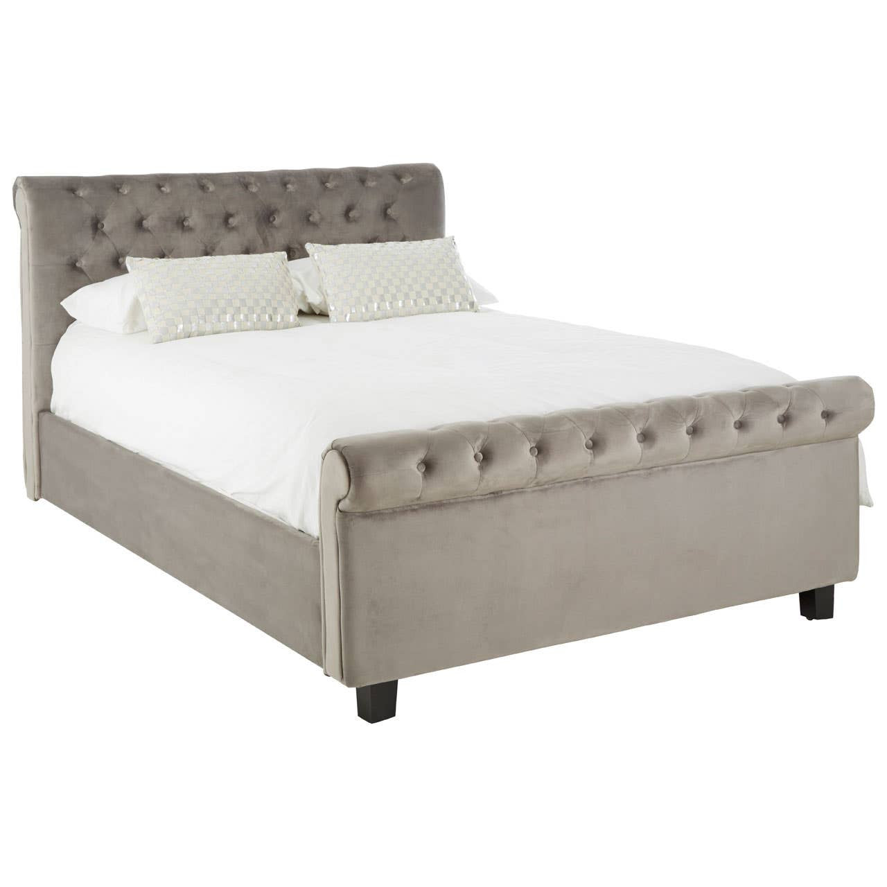 Grey upholstered king bed with a tufted headboard, featuring two decorative pillows and a white mattress, resting on dark wooden legs