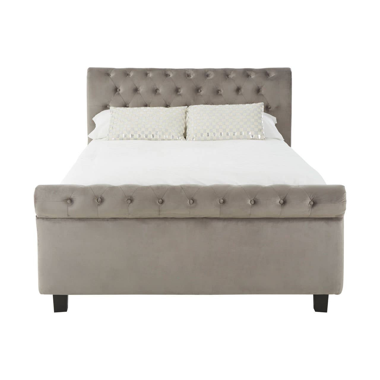 Grey upholstered king bed with a tufted headboard, featuring a padded design and decorative buttons, resting on four black legs. The bed is shown without bedding, highlighting its clean lines and modern aesthetic