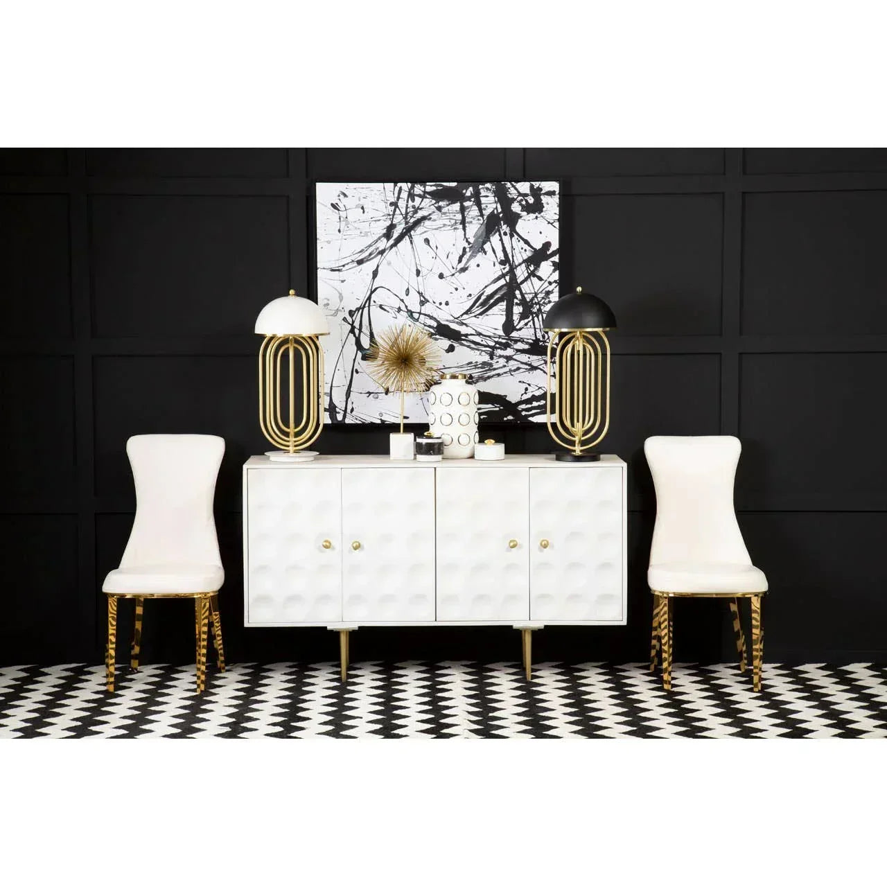 Modern white sideboard with geometric doors, gold lamps, accent chairs and abstract wall art