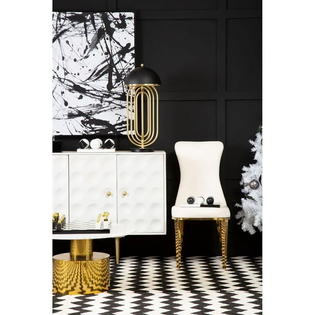 Modern living room with white accent chair, gold legs, geometric coffee table, and sideboard