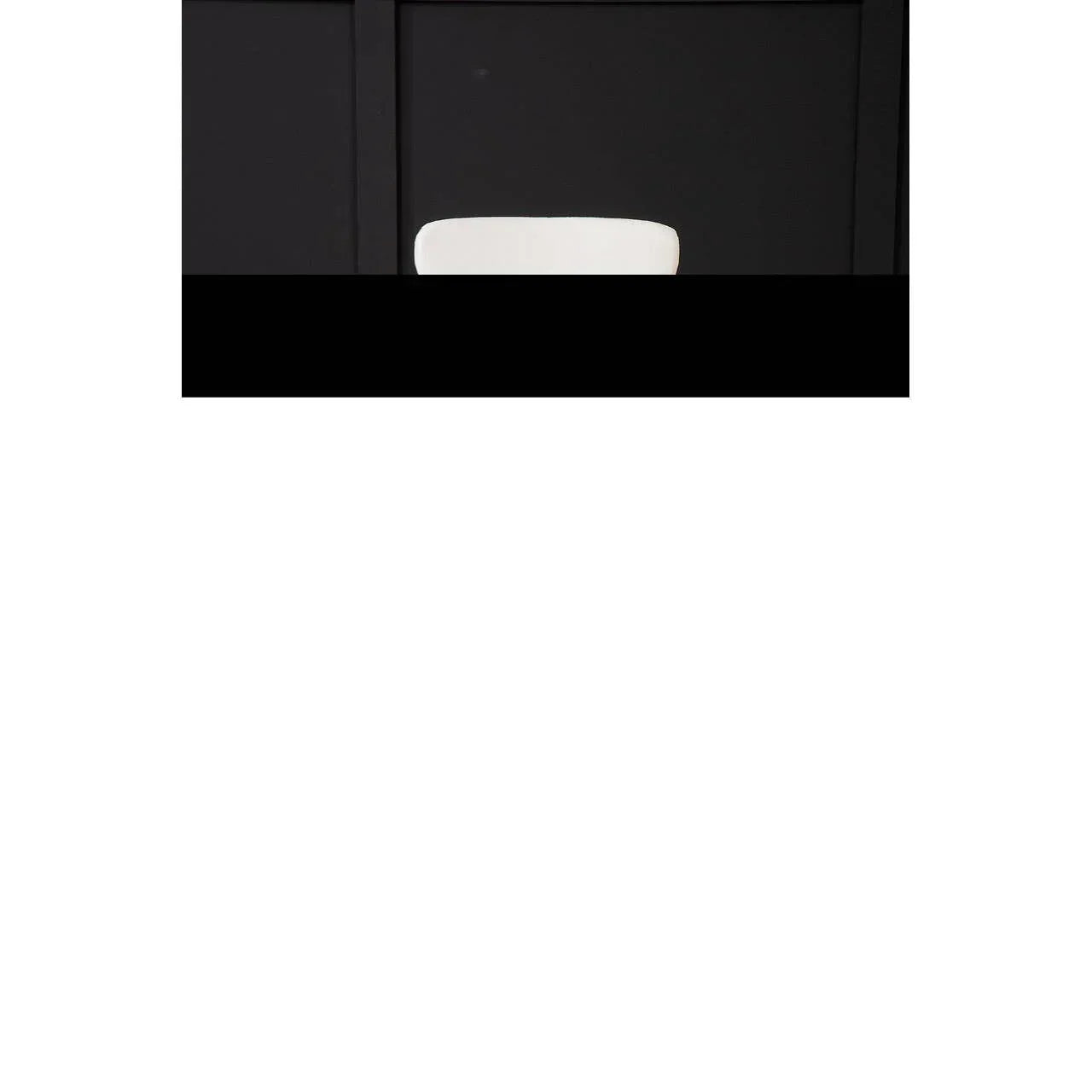 White dining chair with curved backrest against black paneled wall