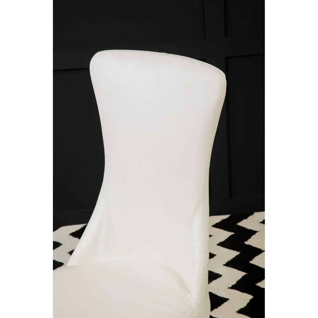 White leather dining chair with curved backrest on black and white chevron rug