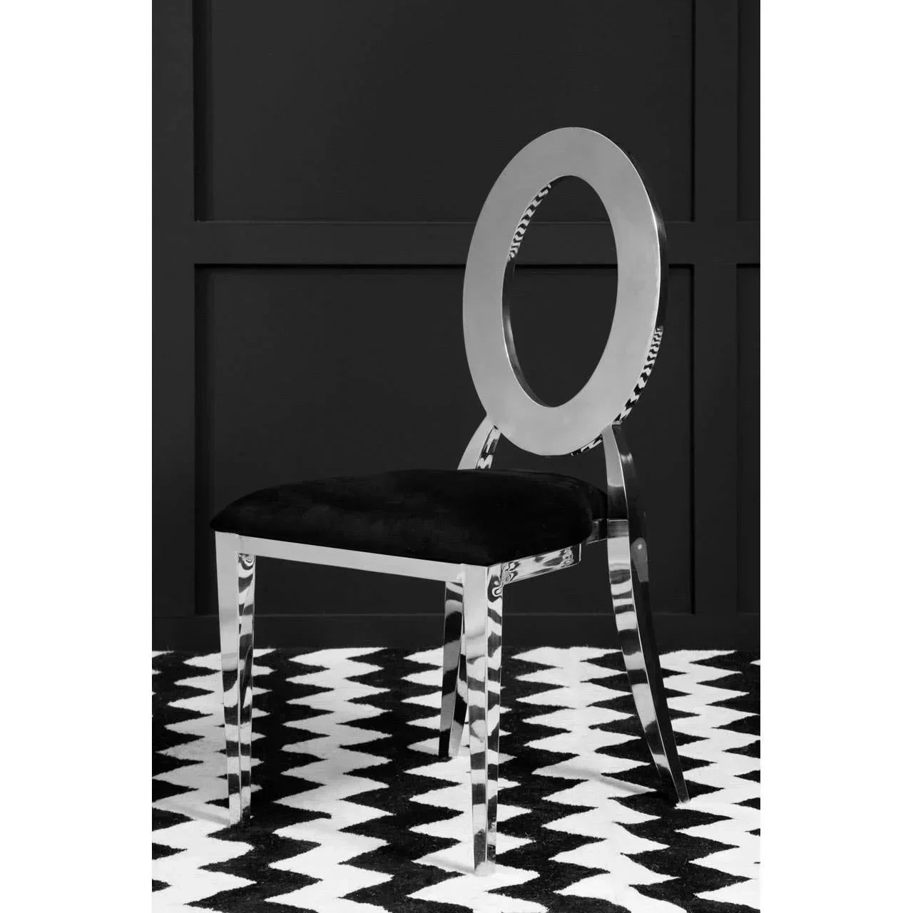 Modern dining chair with oval chrome backrest and black velvet seat on patterned rug