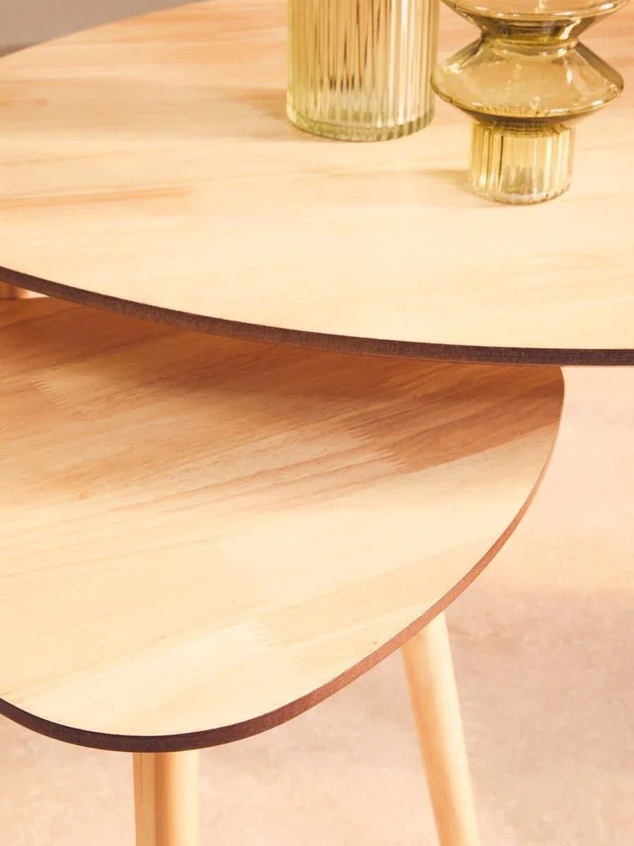 Nested light wood coffee tables with glass vases, close up on smooth rounded edges