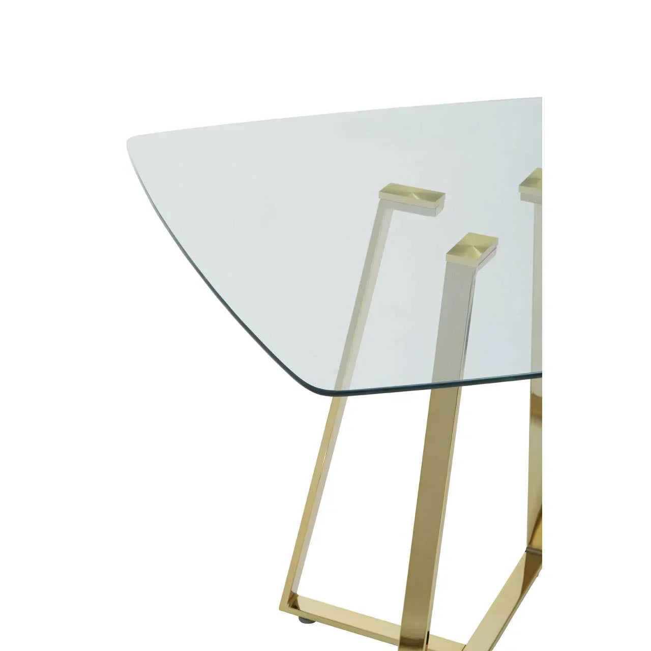 Glass dining table with gold metal legs and triangular top, close-up corner detail