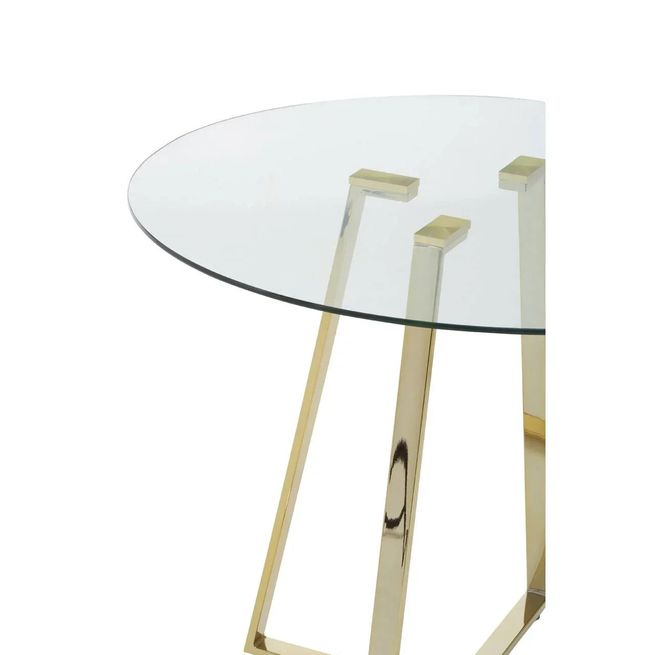 Round glass dining table with gold metal legs, modern design close-up