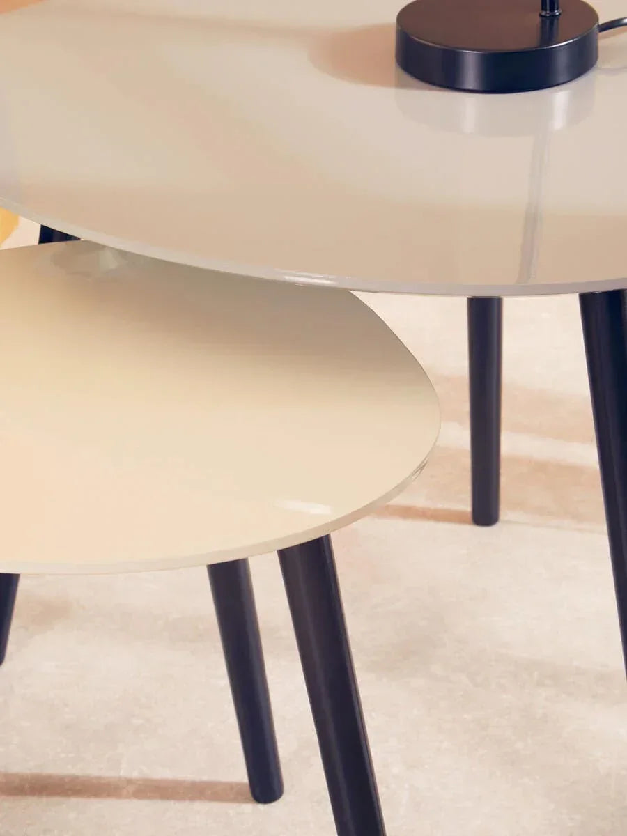 Nesting tables with round gloss tops and black legs on light floor