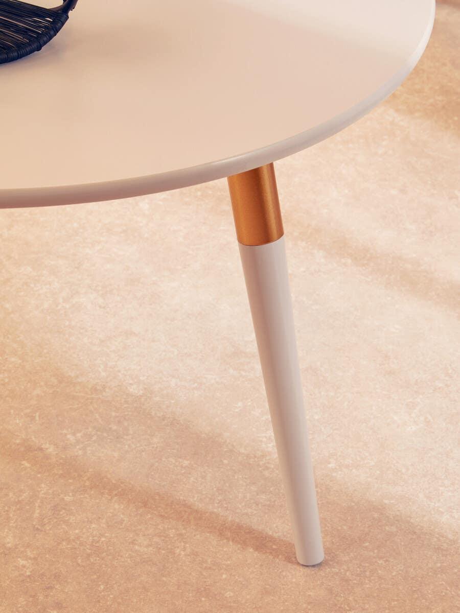 Round white table with gold accent leg on beige tiled floor