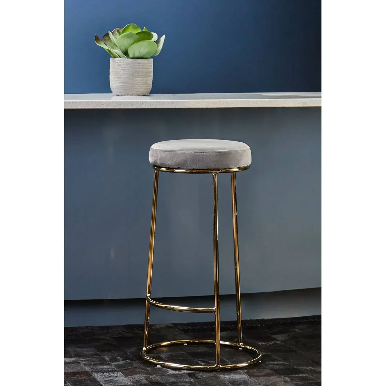 Grey velvet bar stool with gold metal legs at blue kitchen breakfast bar
