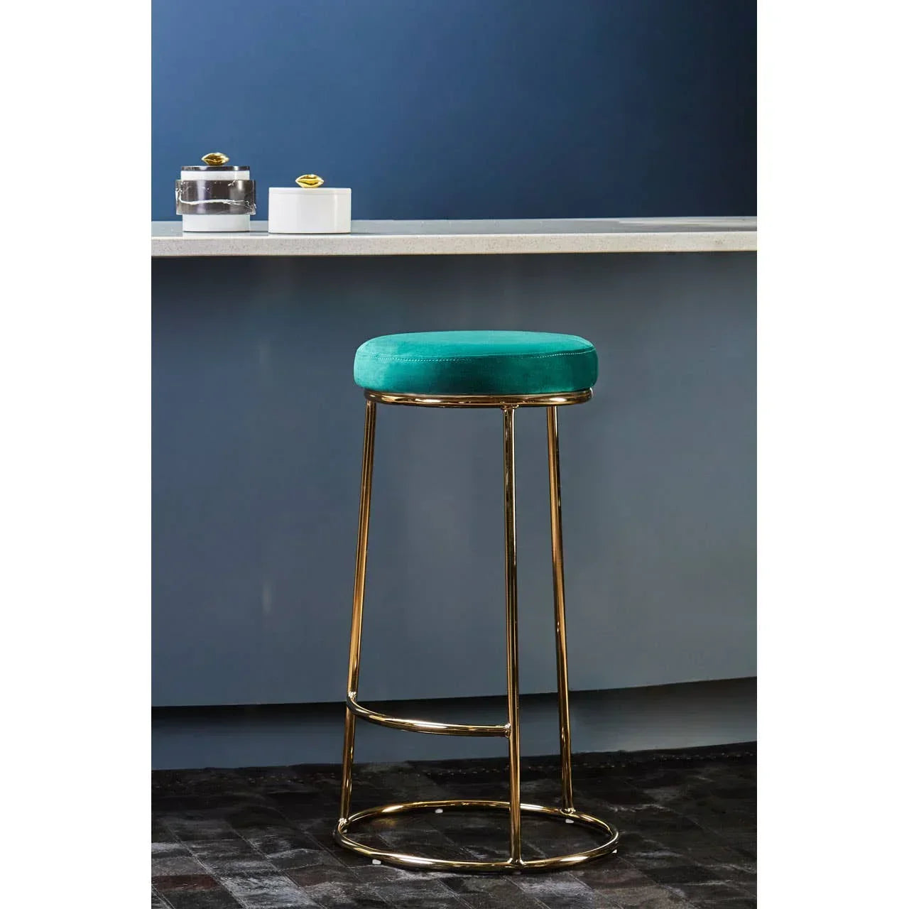 Velvet bar stool with teal cushioned seat and gold metal frame beside modern kitchen counter