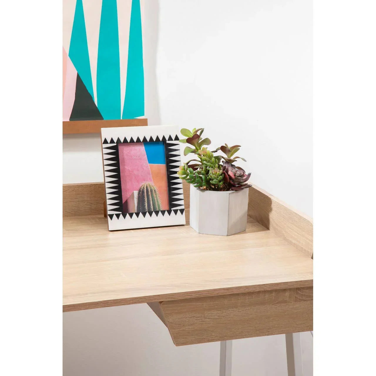 Wooden home office desk with geometric frame and potted succulents in white planter