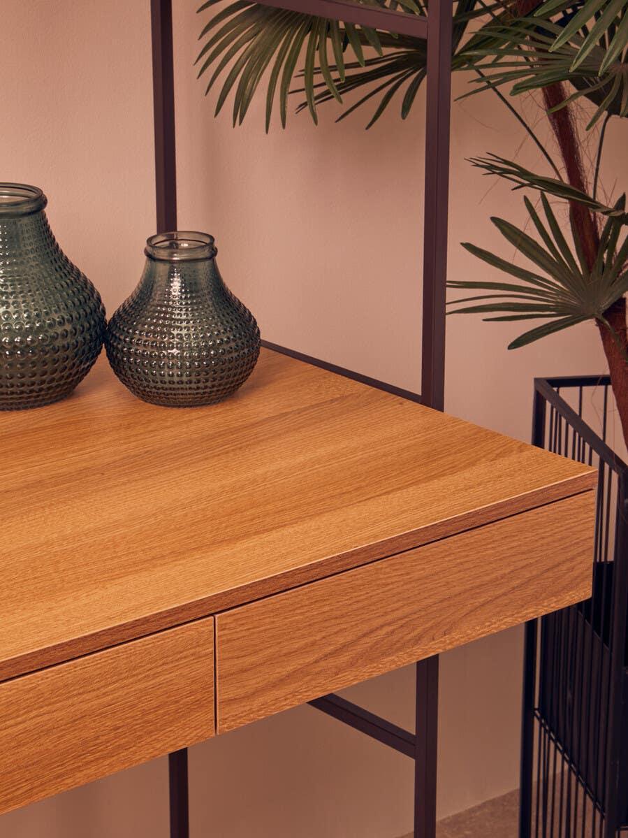 Oak wood desk with black metal legs, drawers, green vases, and indoor plant decor