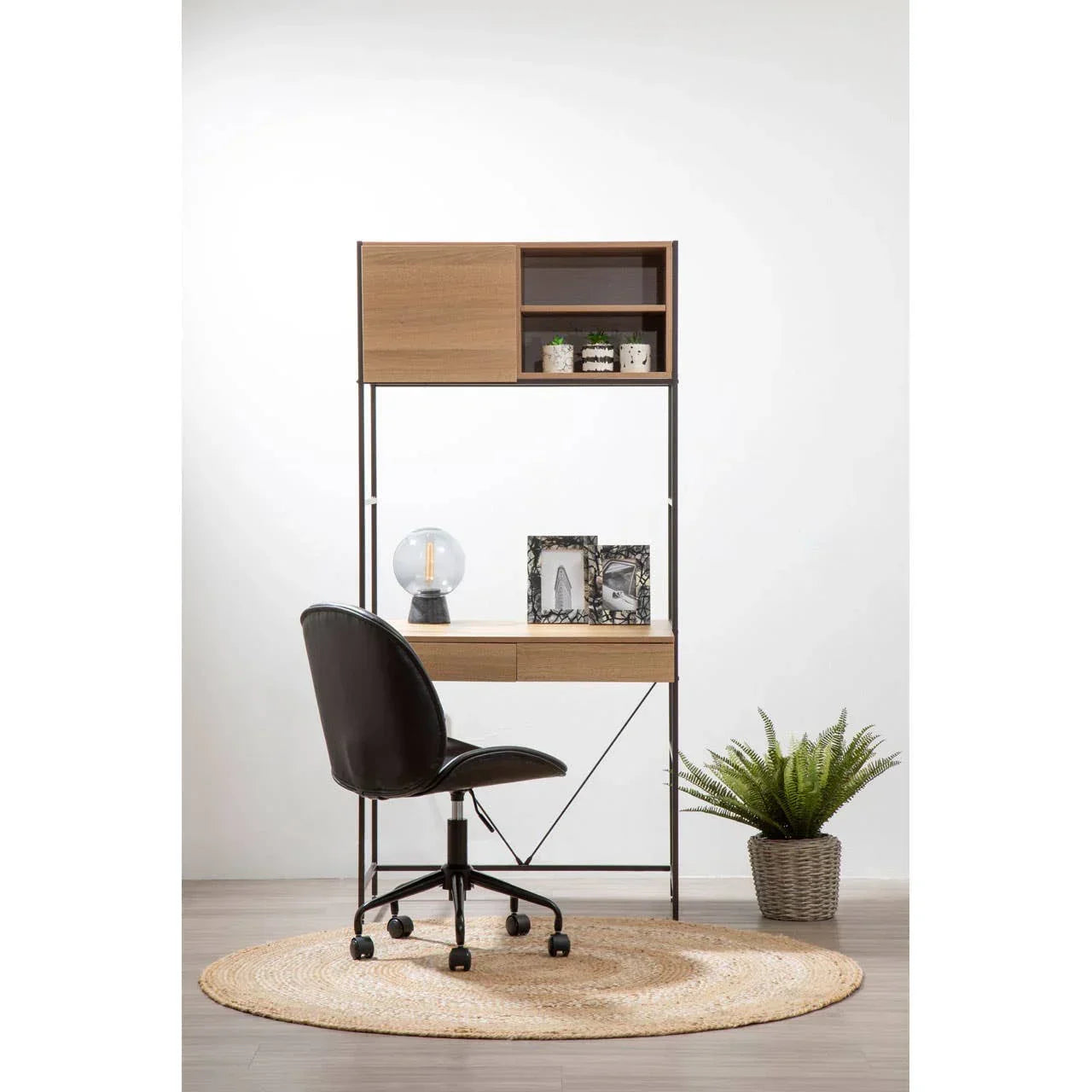Wooden home office desk with shelves, black swivel chair, and decorative items on rug