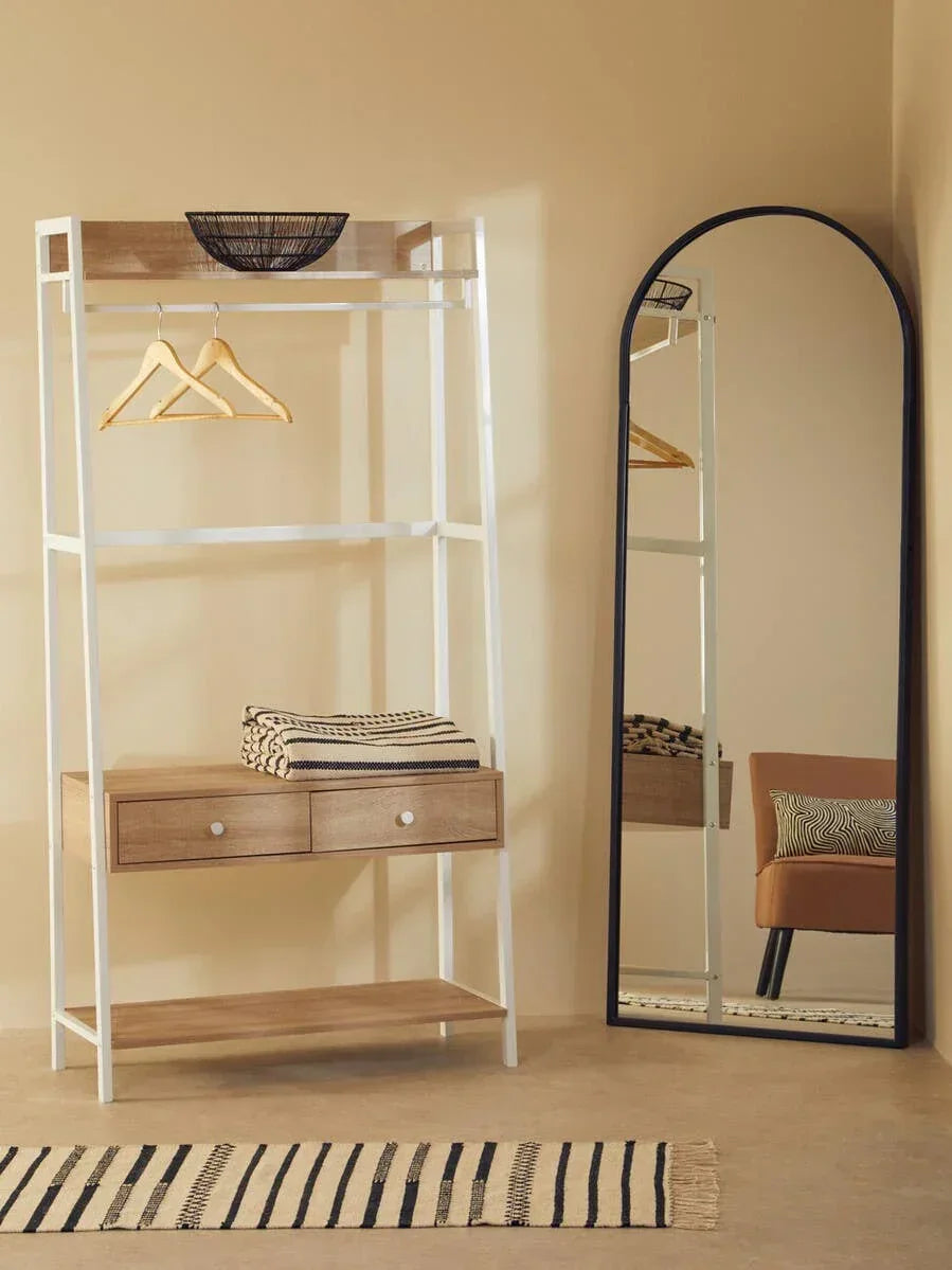 Wood and metal hallway storage rack with drawers beside arched full-length mirror