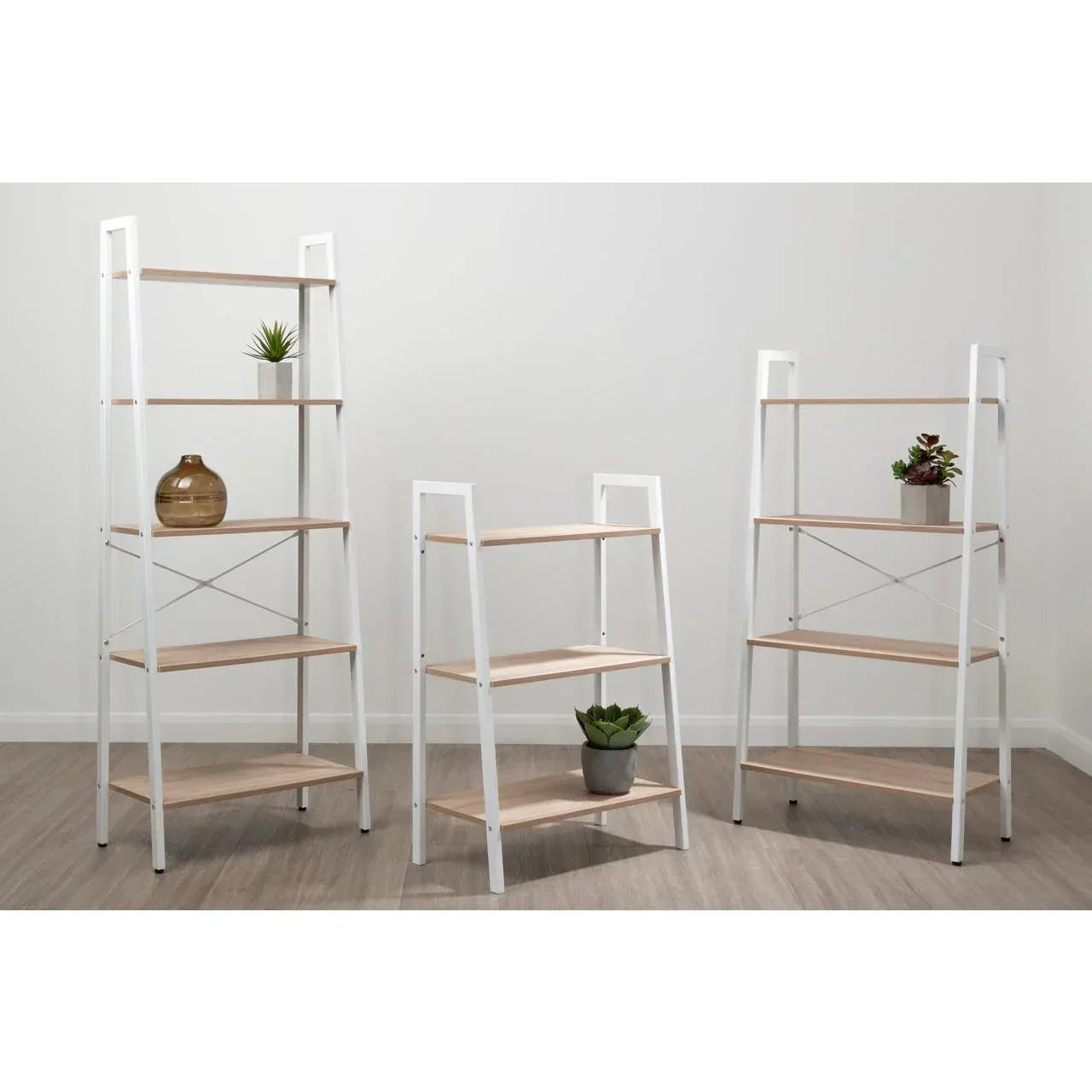 White metal and light wood ladder shelves set with plants and vases in modern room