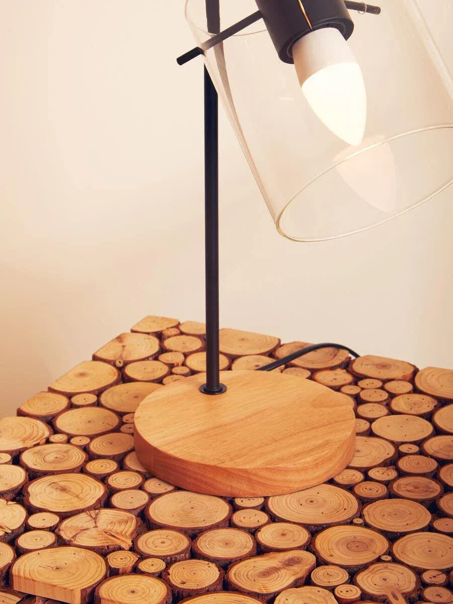 Wooden lamp with glass shade on round log slice side table