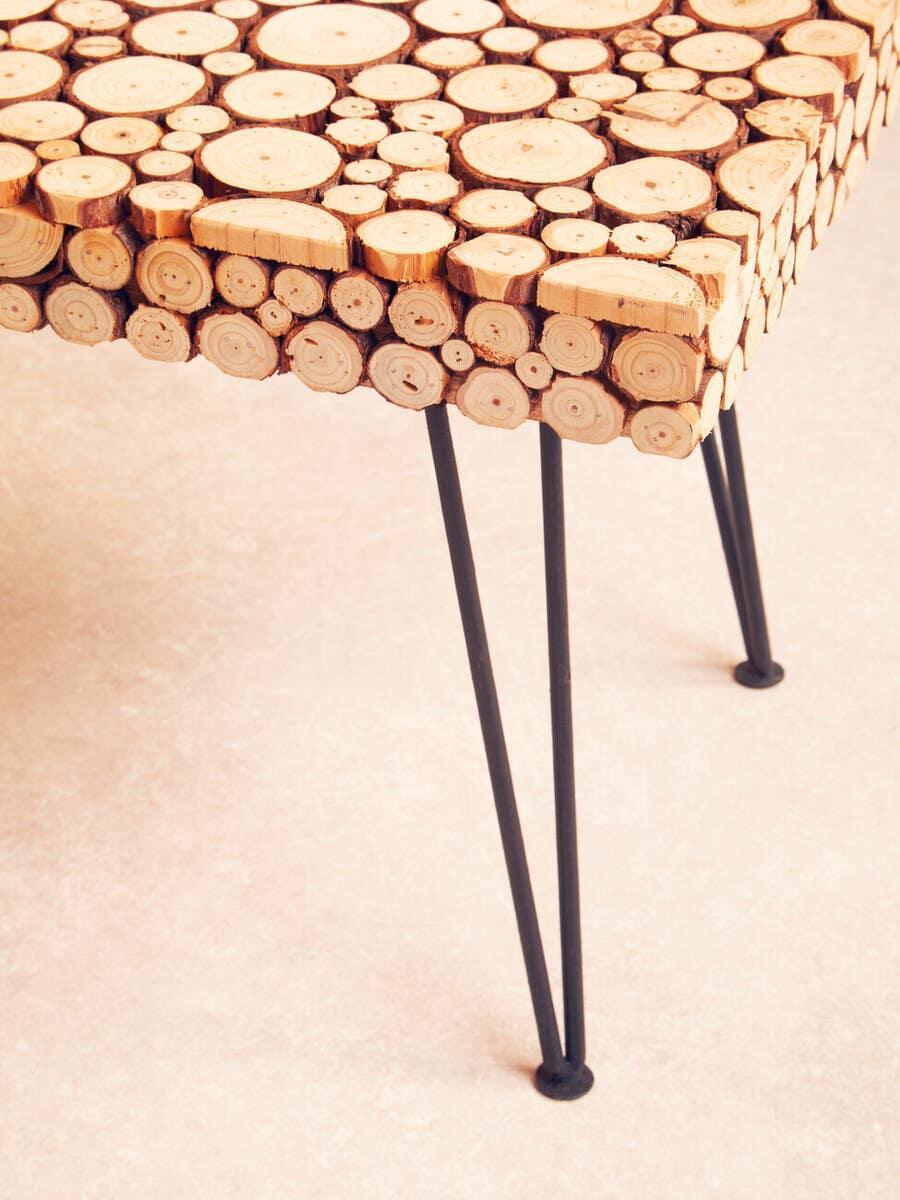 wood slice coffee table with black metal hairpin legs on light floor