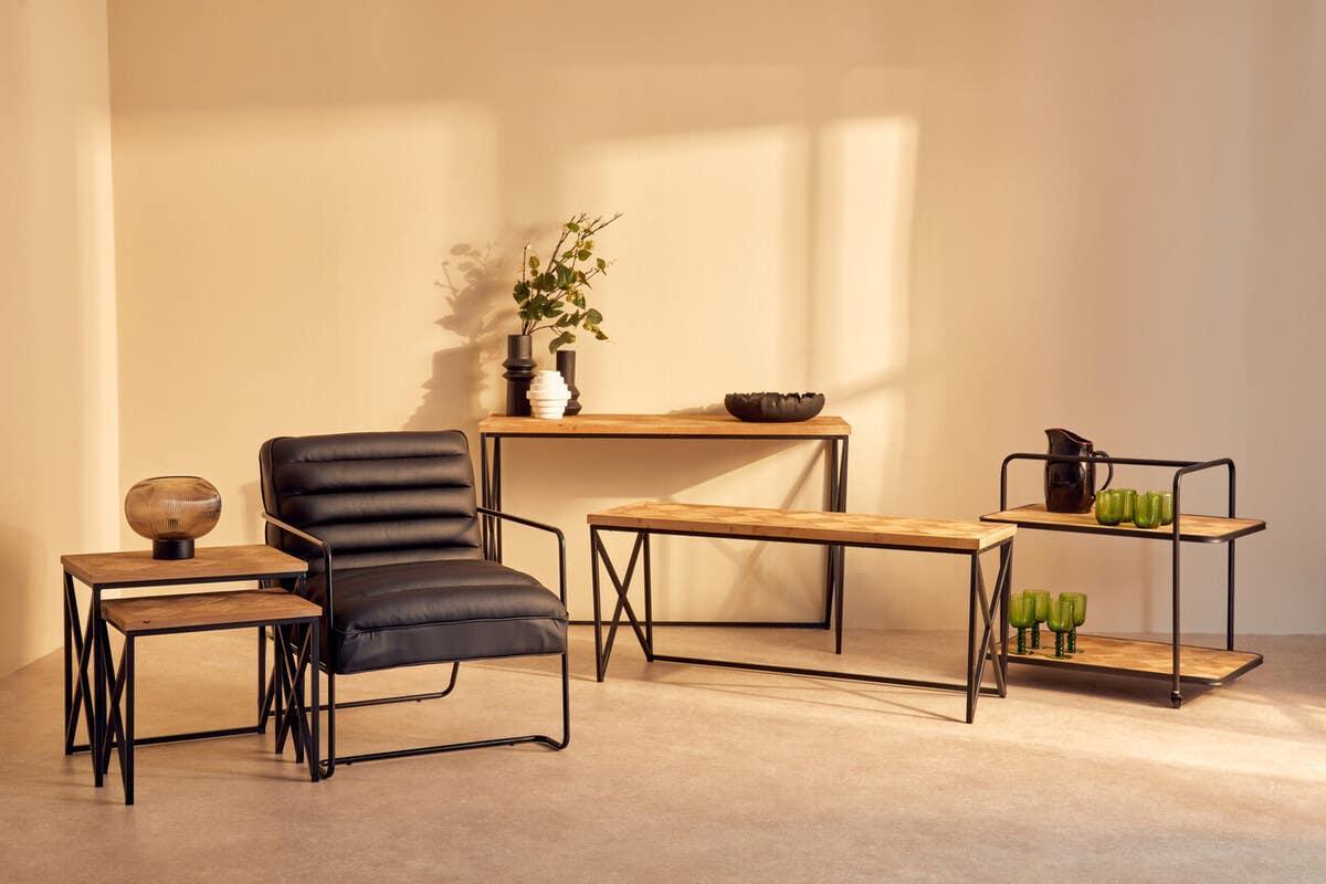 Modern black armchair with metal frame, wood coffee tables and console table in bright living room