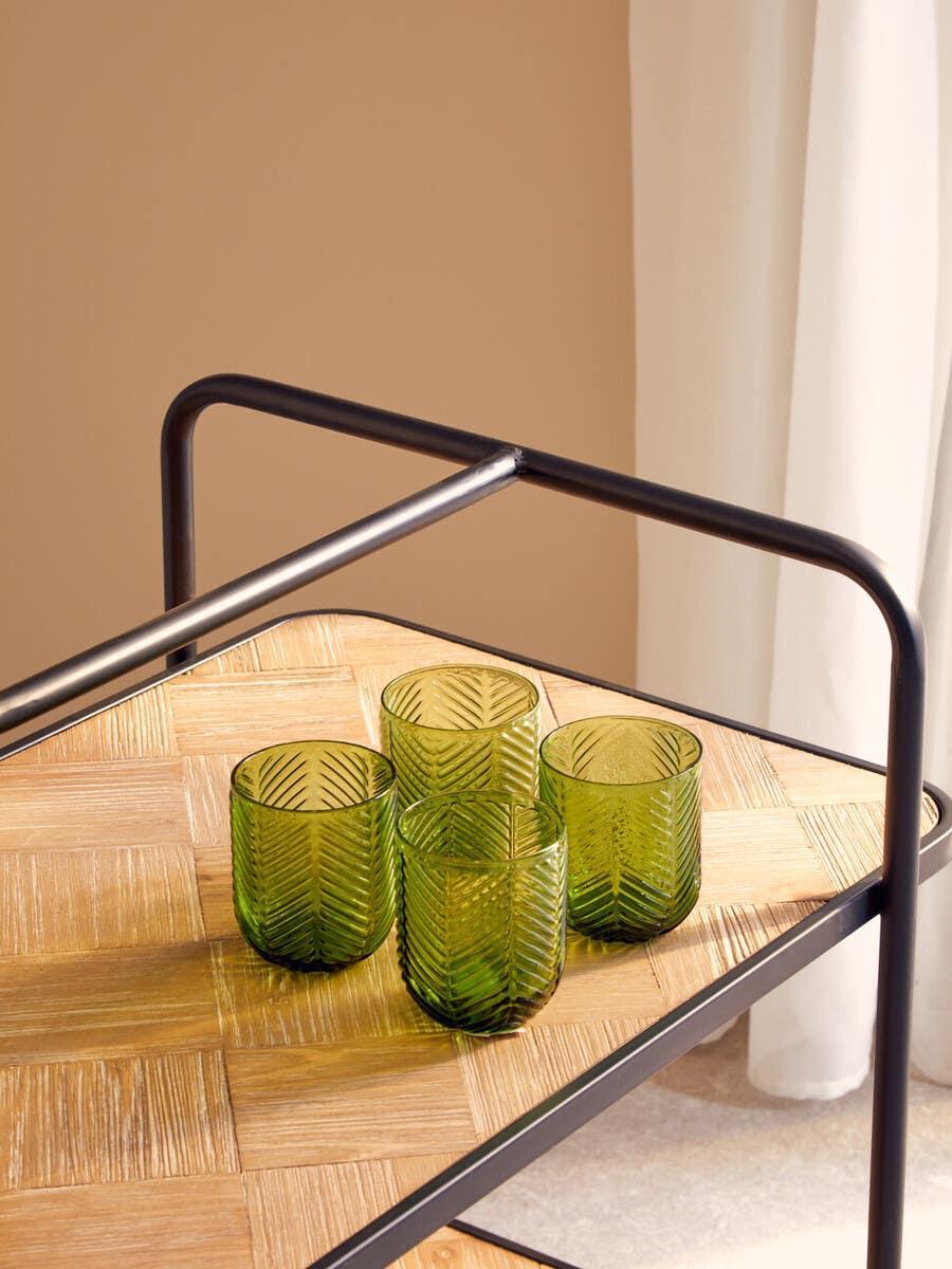 Set of four green textured glass tumblers on wooden drinks trolley with metal frame