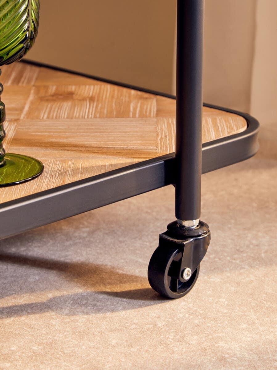 Black metal trolley wheel and wood effect shelf on indoor floor