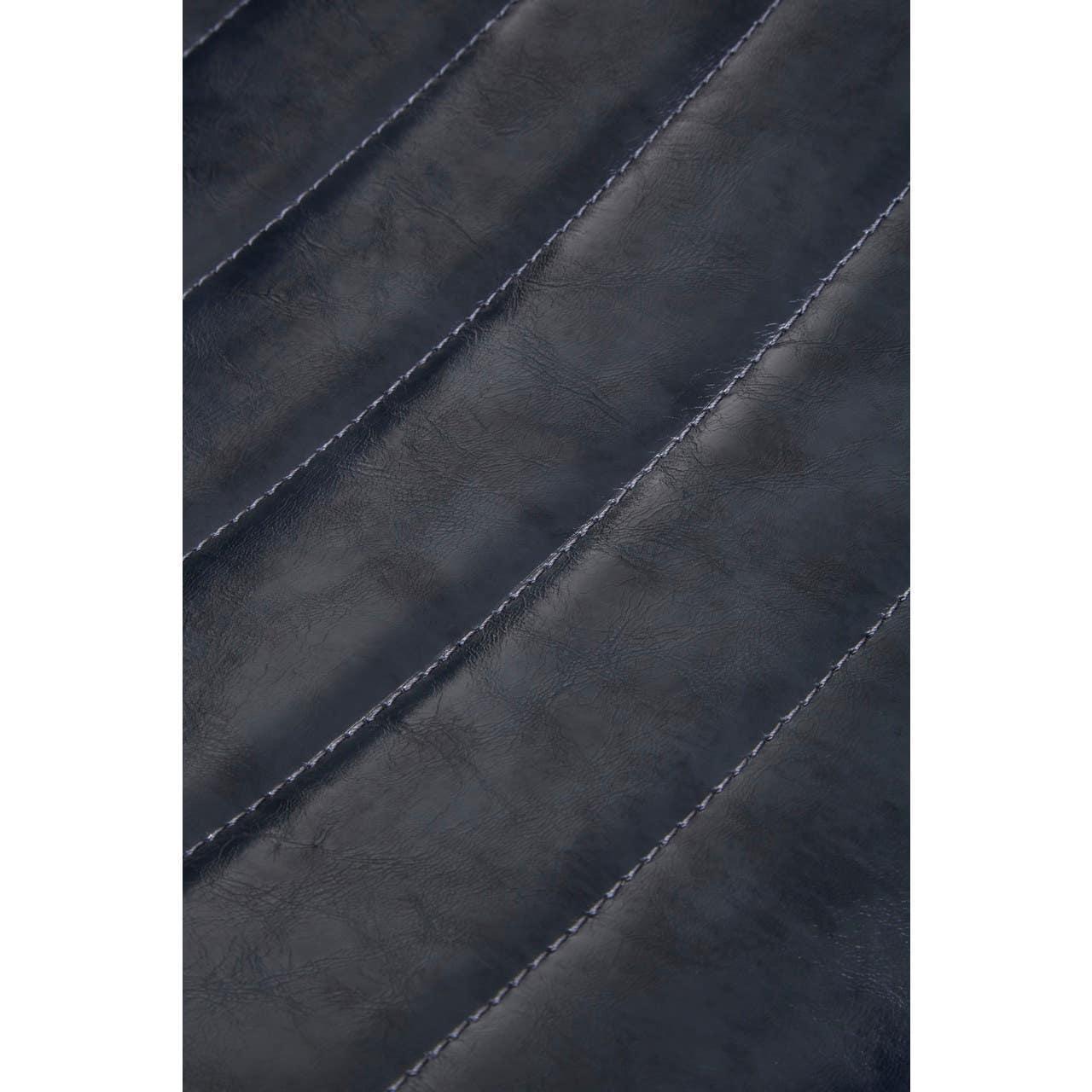 Closeup of dark blue faux leather upholstery with stitched channel detail