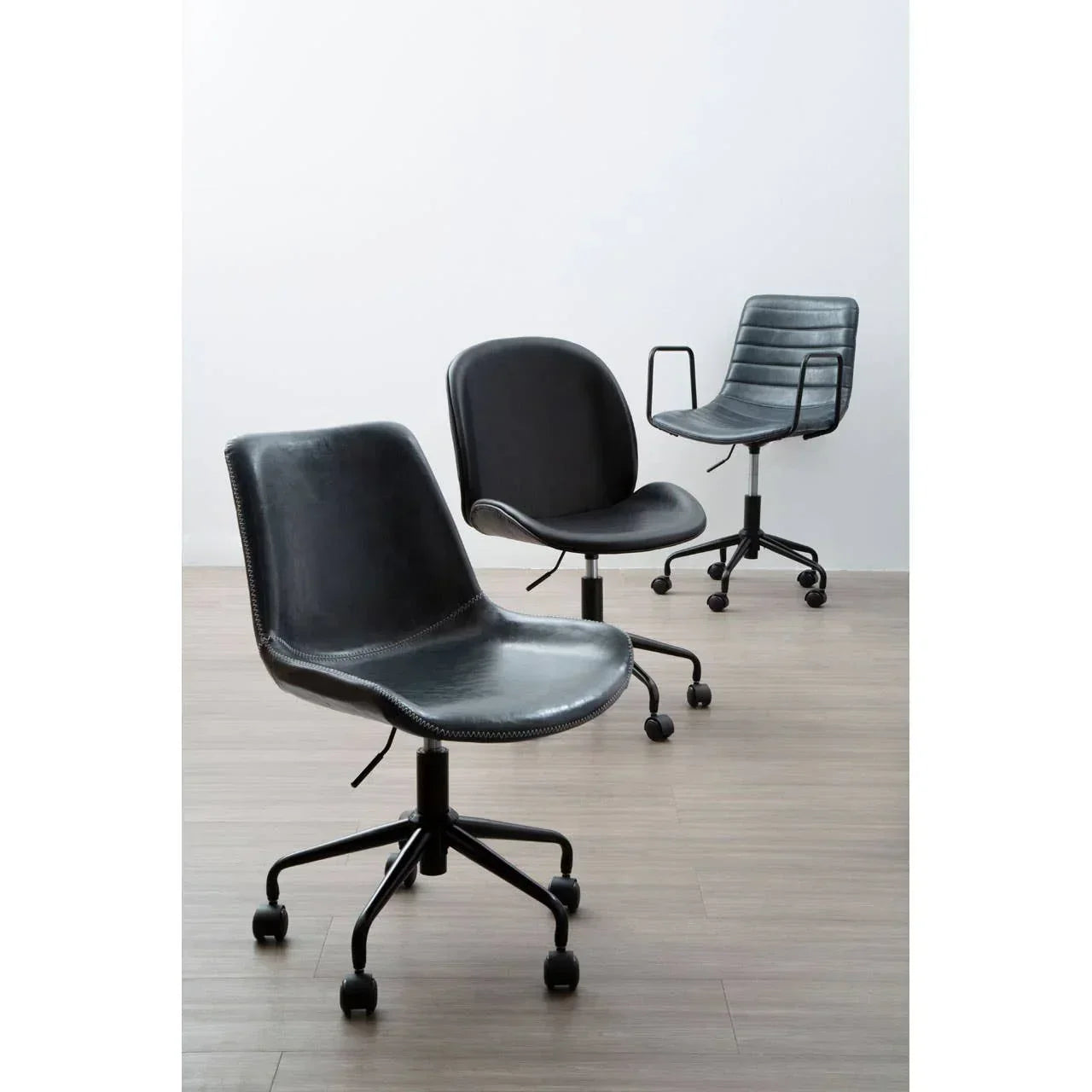 Black faux leather office chairs with casters on wood floor
