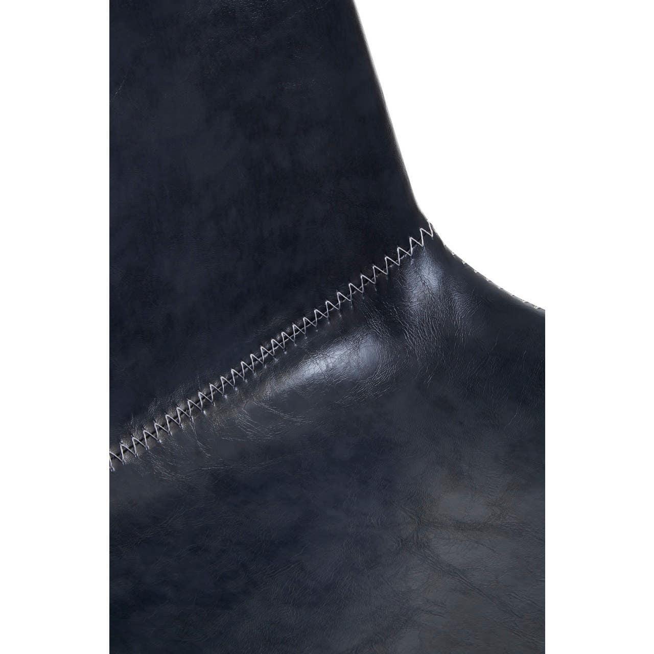 Close-up of dark faux leather chair back with white zigzag stitch detail