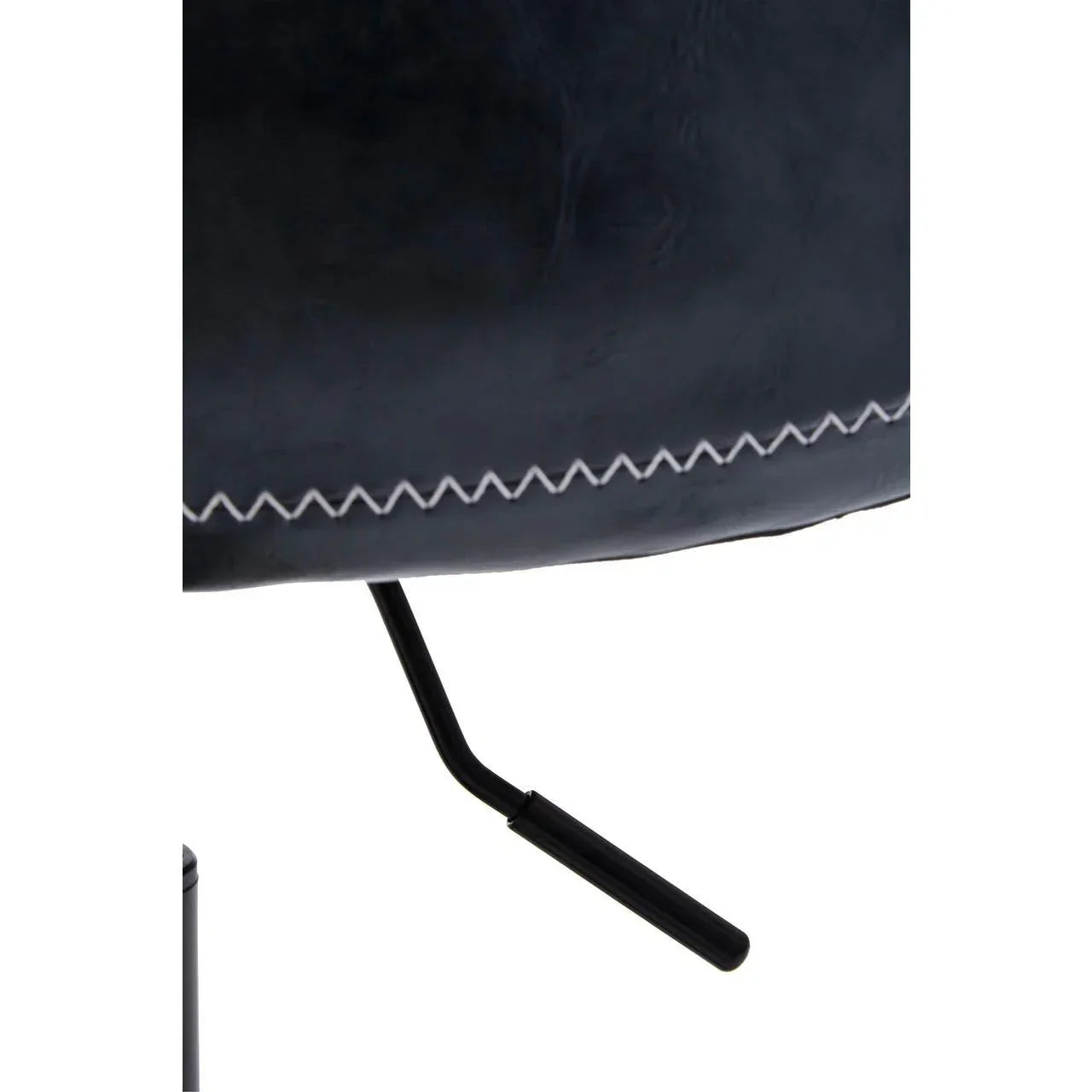 Closeup of stitched black leather chair seat with visible metal leg