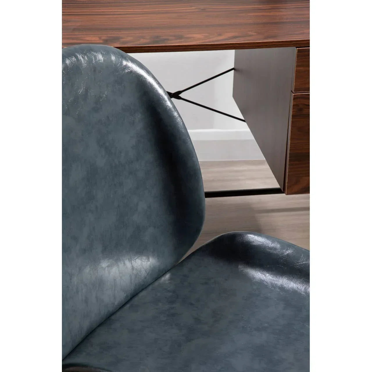 Close-up of blue faux leather dining chair in front of wooden desk with drawers
