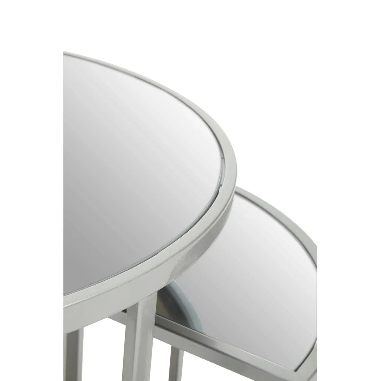Close-up of two round glass nesting tables with silver metal frames