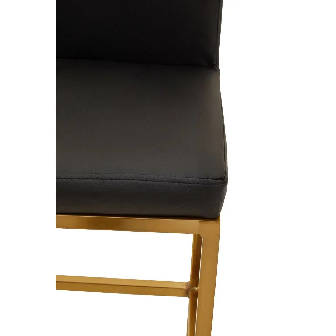 Close-up of black leather dining chair seat with gold metal frame