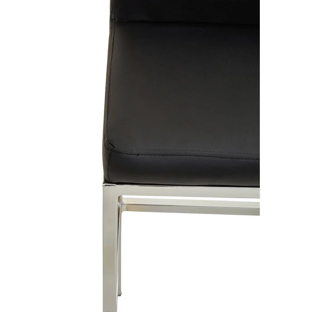 Closeup of black faux leather dining chair seat with chrome metal frame