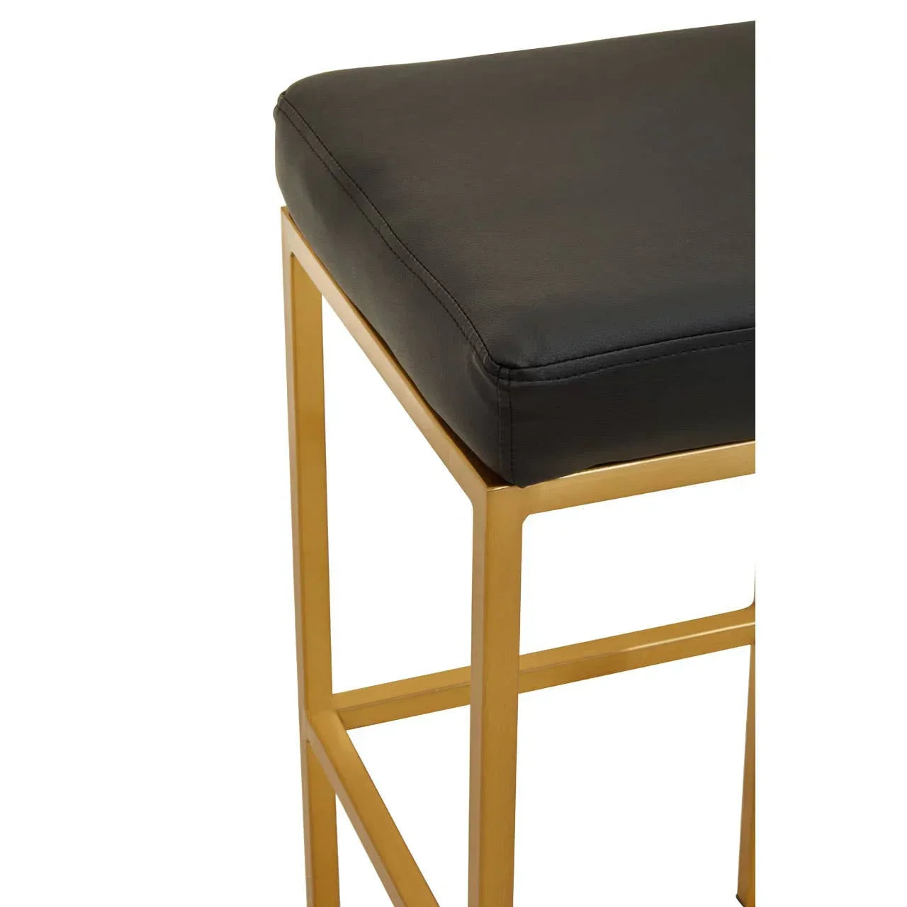 Black leather bar stool with gold metal frame, close-up of seat and legs