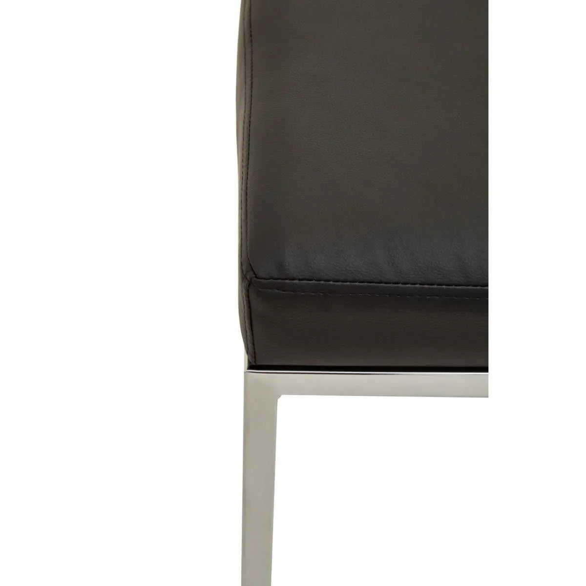 Close-up of black leather sofa cushion and chrome leg