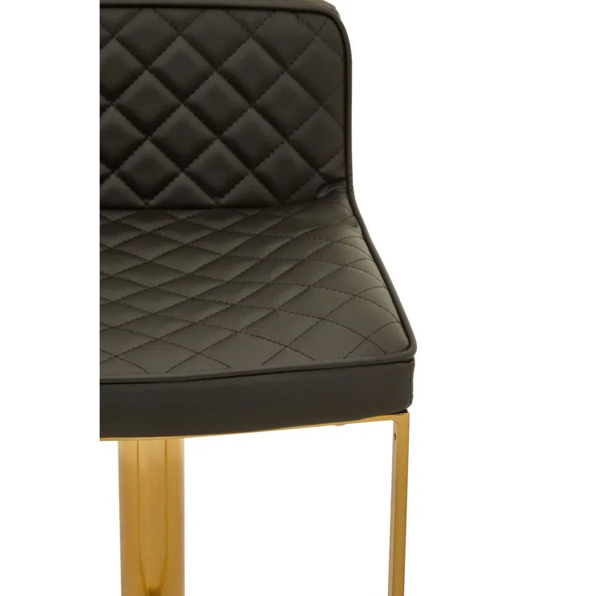 Black quilted dining chair seat with gold metal legs, close-up angle
