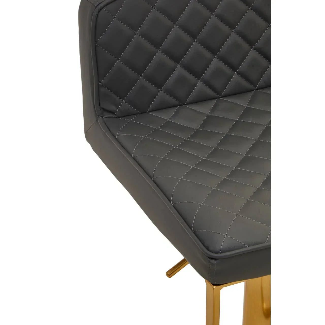 Close-up of quilted black dining chair seat with gold metal legs