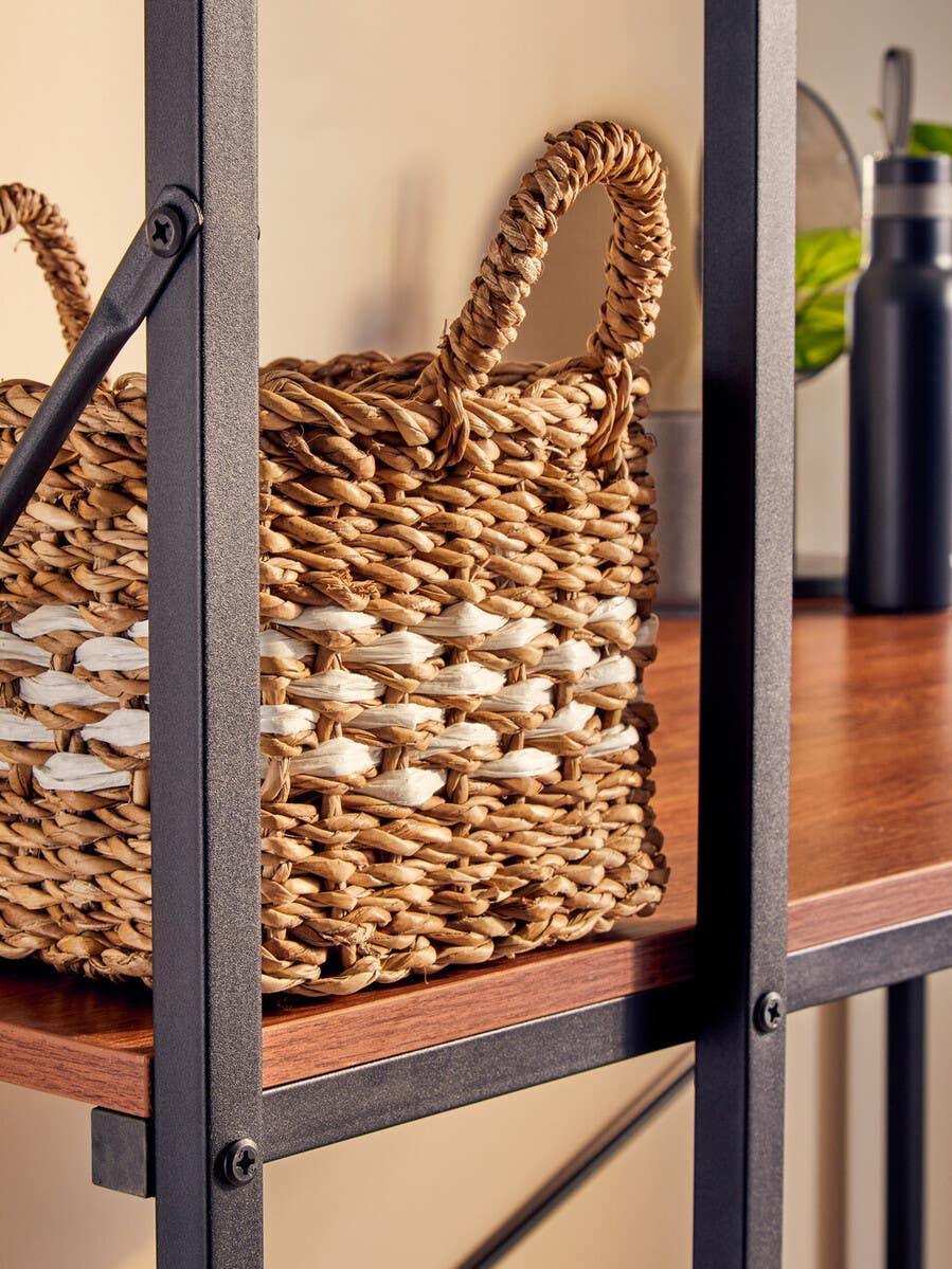 Woven storage basket with handles on wooden shelf with black metal frame