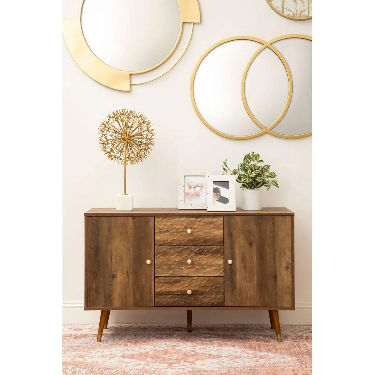Mid-century wood sideboard with textured drawers, gold knobs, and decor in modern living room