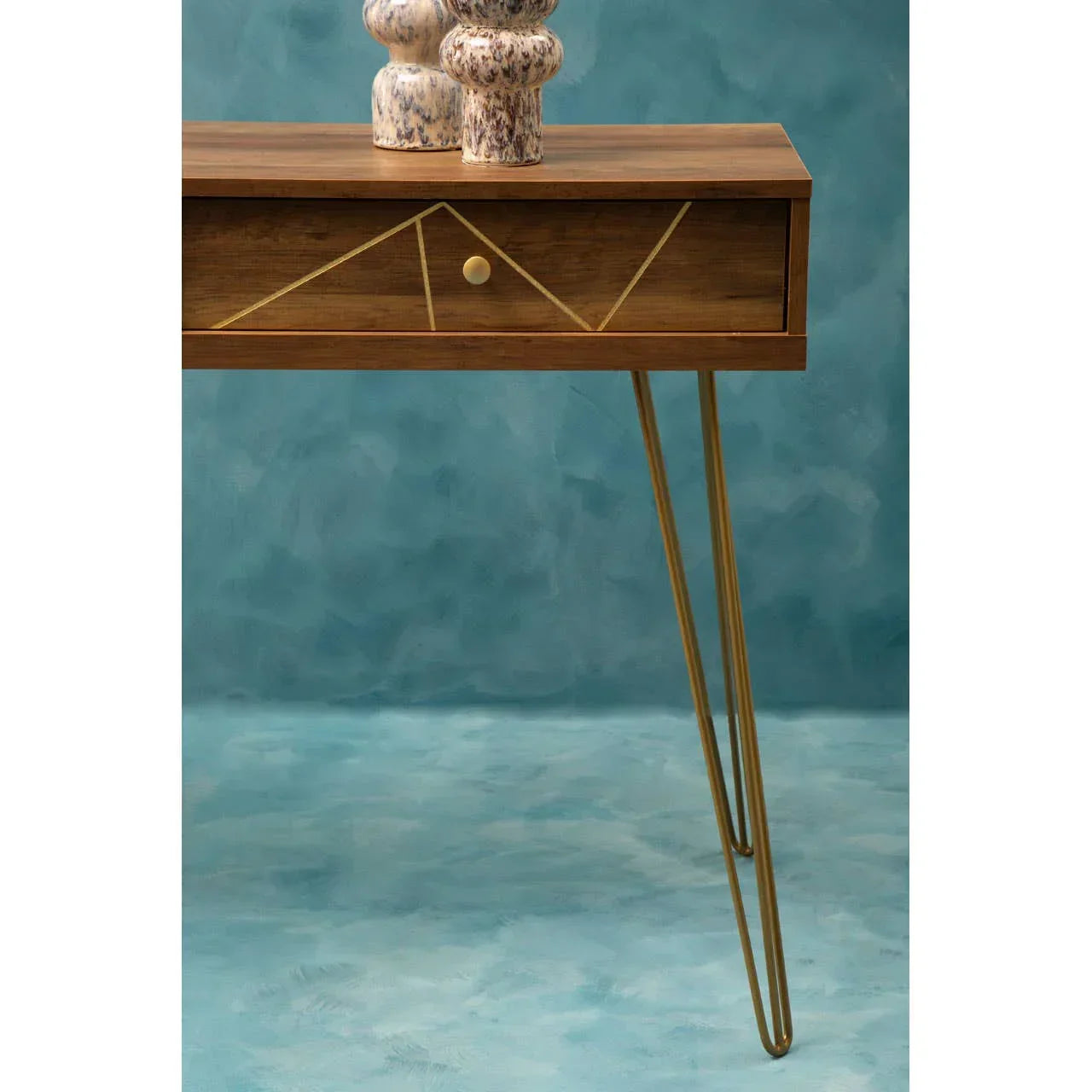 Wood console table with gold metal legs and geometric drawer front, styled with ceramic vases