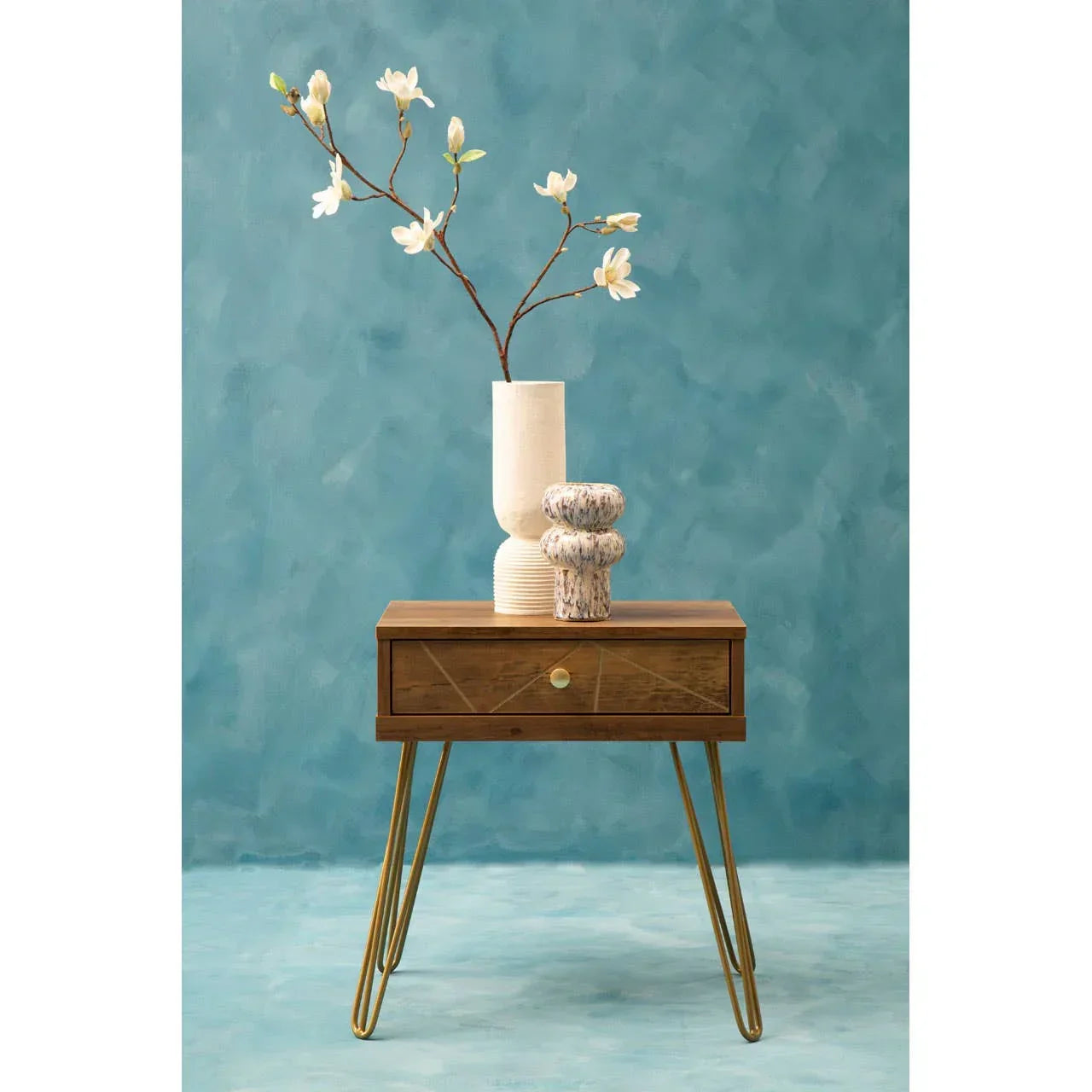 Wooden bedside table with gold hairpin legs and decorative vases against blue wall