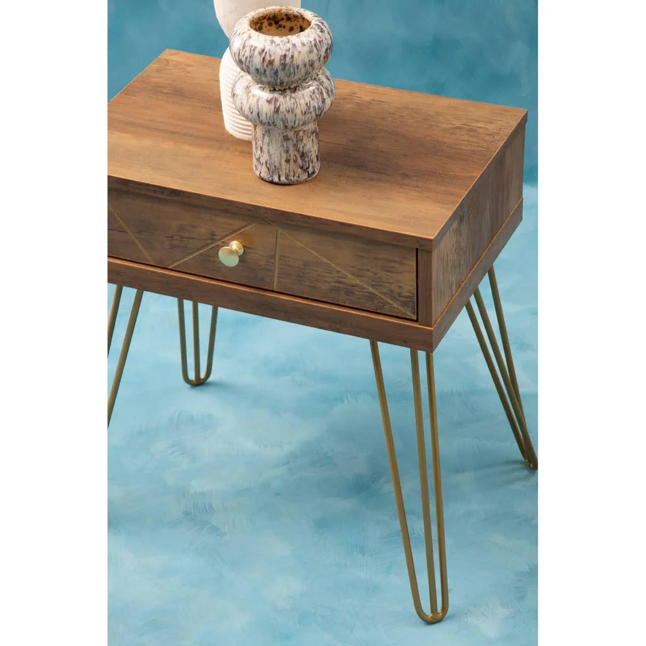 Wooden bedside table with gold hairpin legs and drawer, ceramic vases on top
