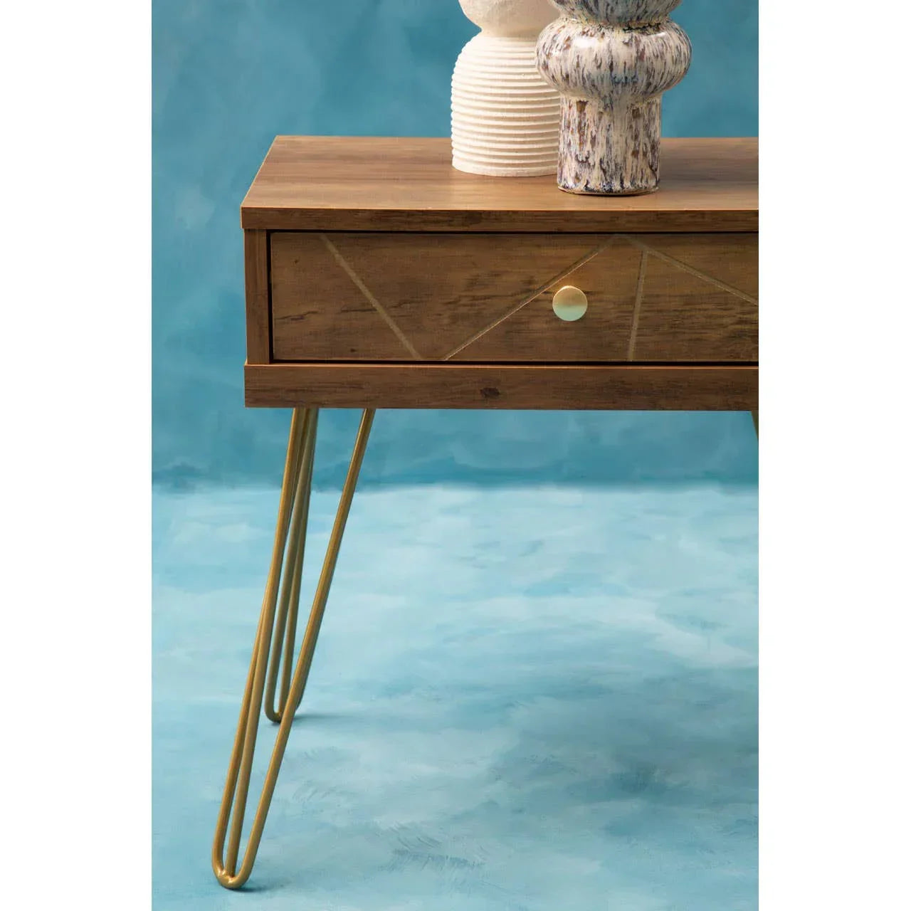 Wooden bedside table with gold hairpin legs and single drawer, decorative vases on top