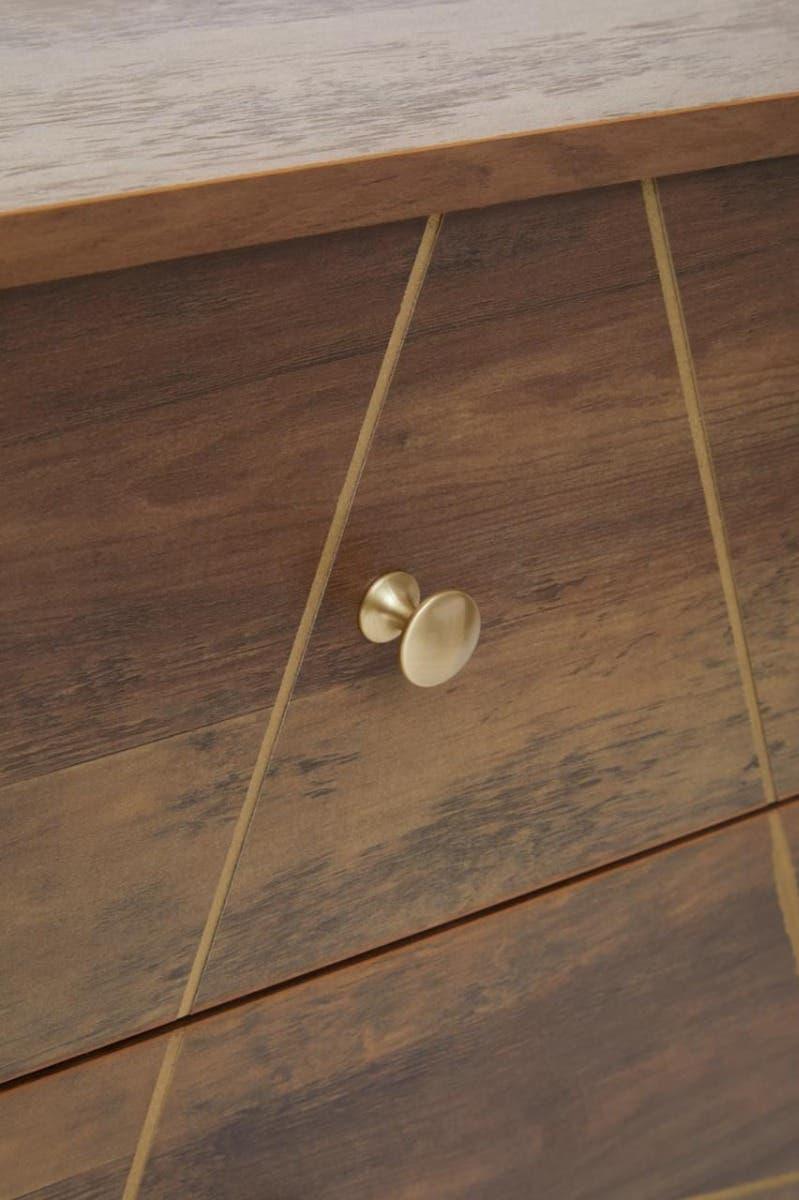 Close-up of wooden drawer front with gold knob and geometric inlay accents