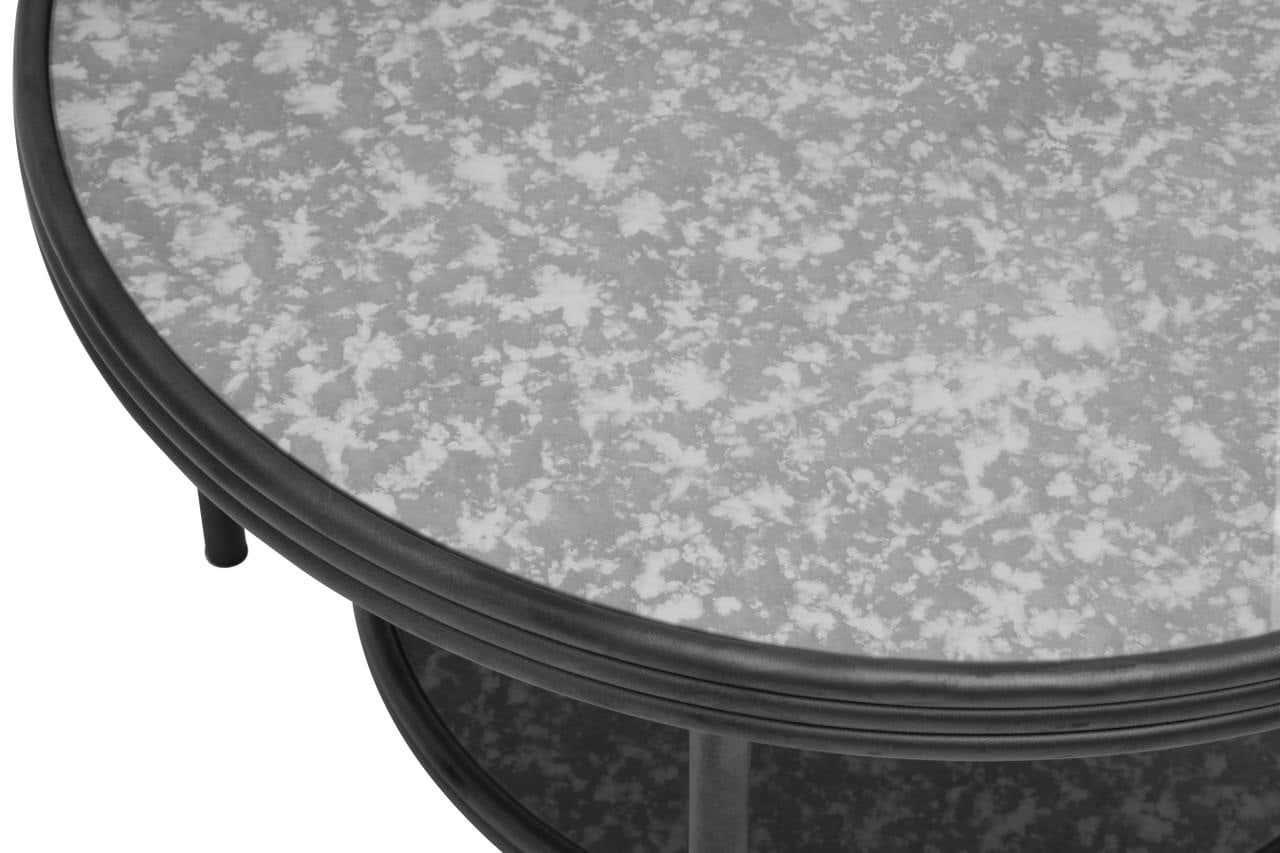 Round coffee table with speckled glass top and black metal frame, close-up view