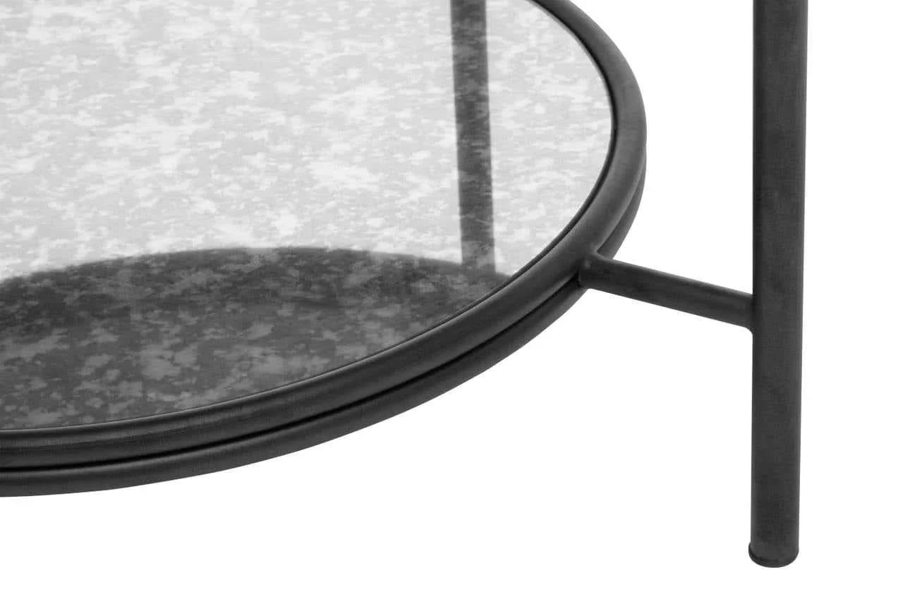 Round glass coffee table with black metal legs and lower shelf detail