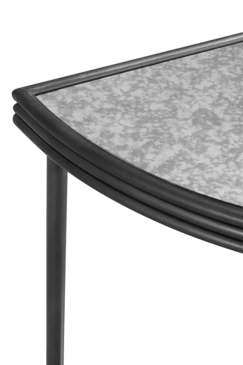 Close up of black metal table leg and edge with speckled glass tabletop